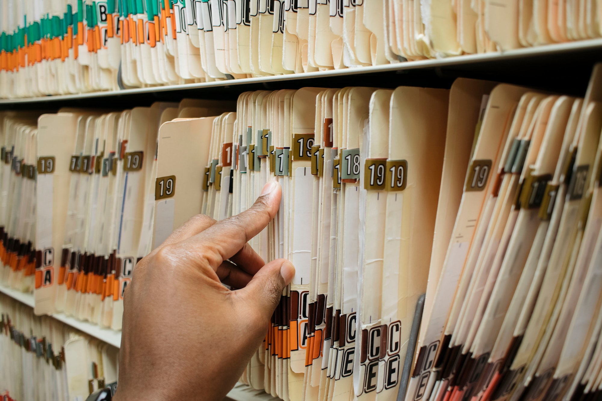 Charts at a medical office, record, archive, African American man pulling a chart